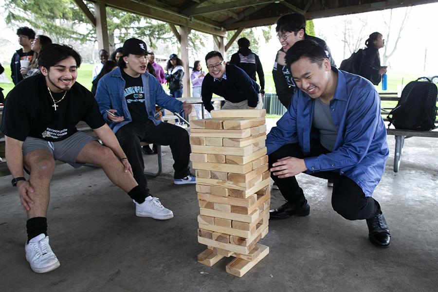 Students from Latinos Unidos gather around to play giant Jenga.