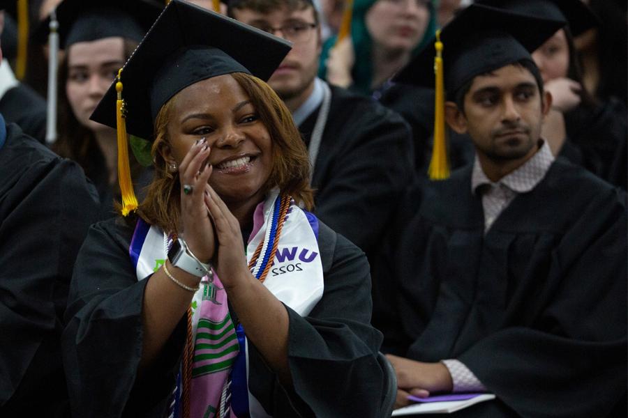 Students clap in the crowd at commencement.