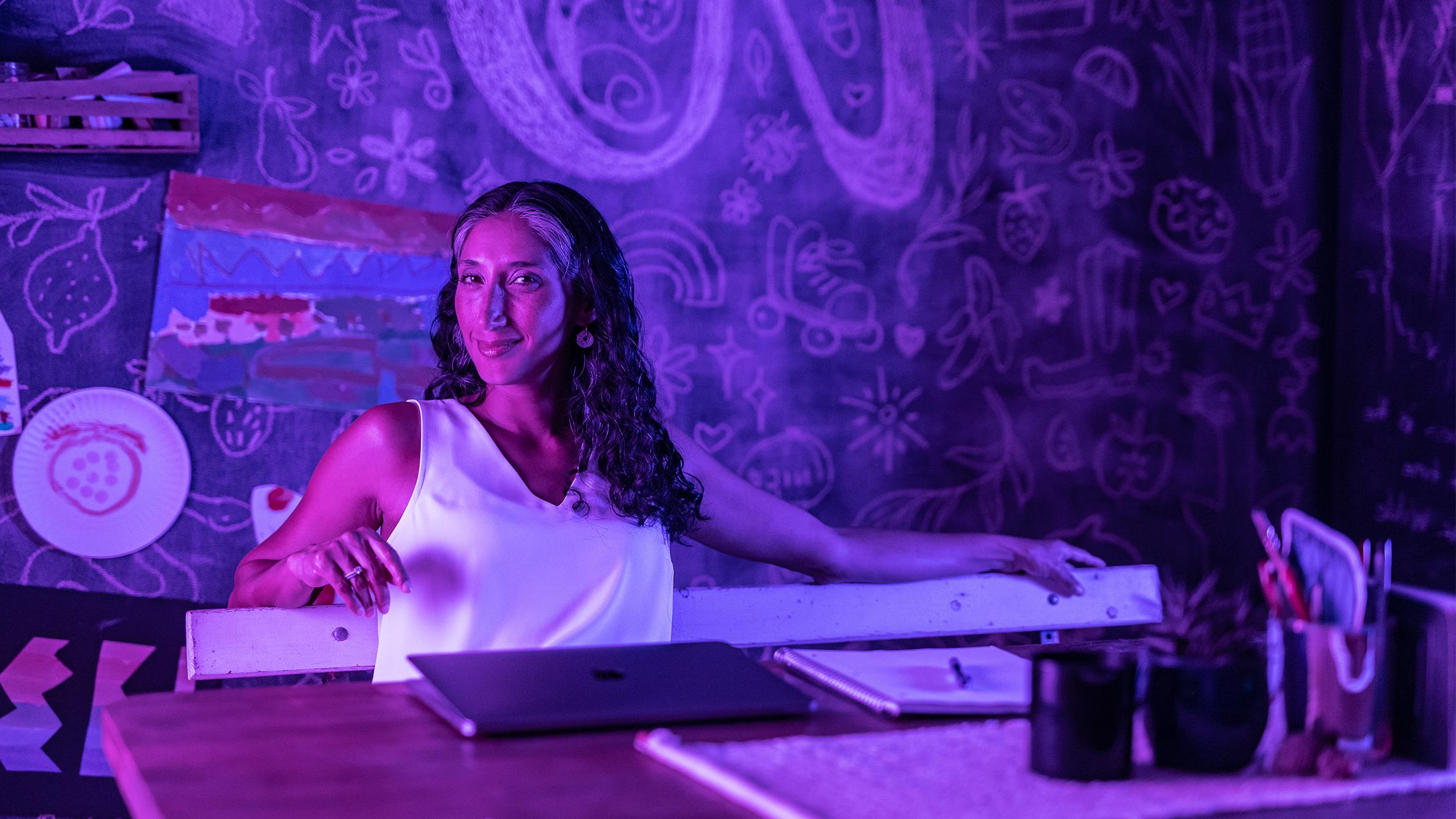 Woman sitting at monitor taking online college class, first video frame